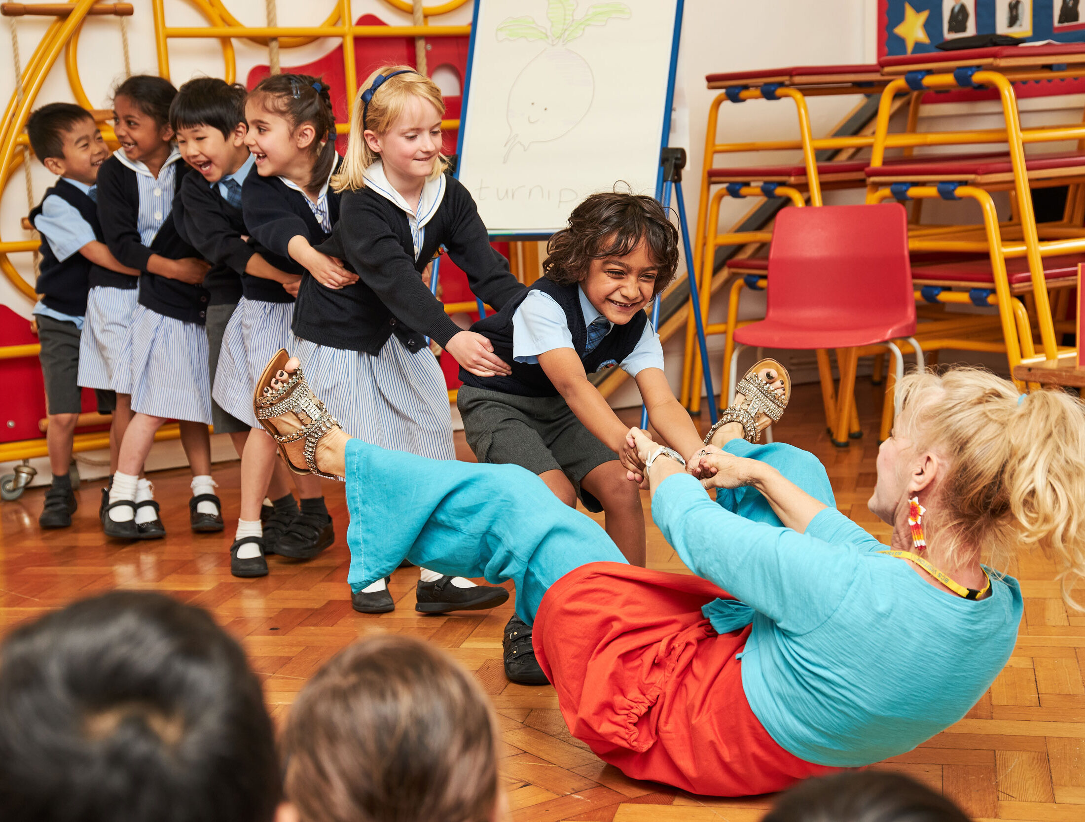 Six Pre-Prep children are pulling a teacher off the floor during a performance of The Giant Turnip.