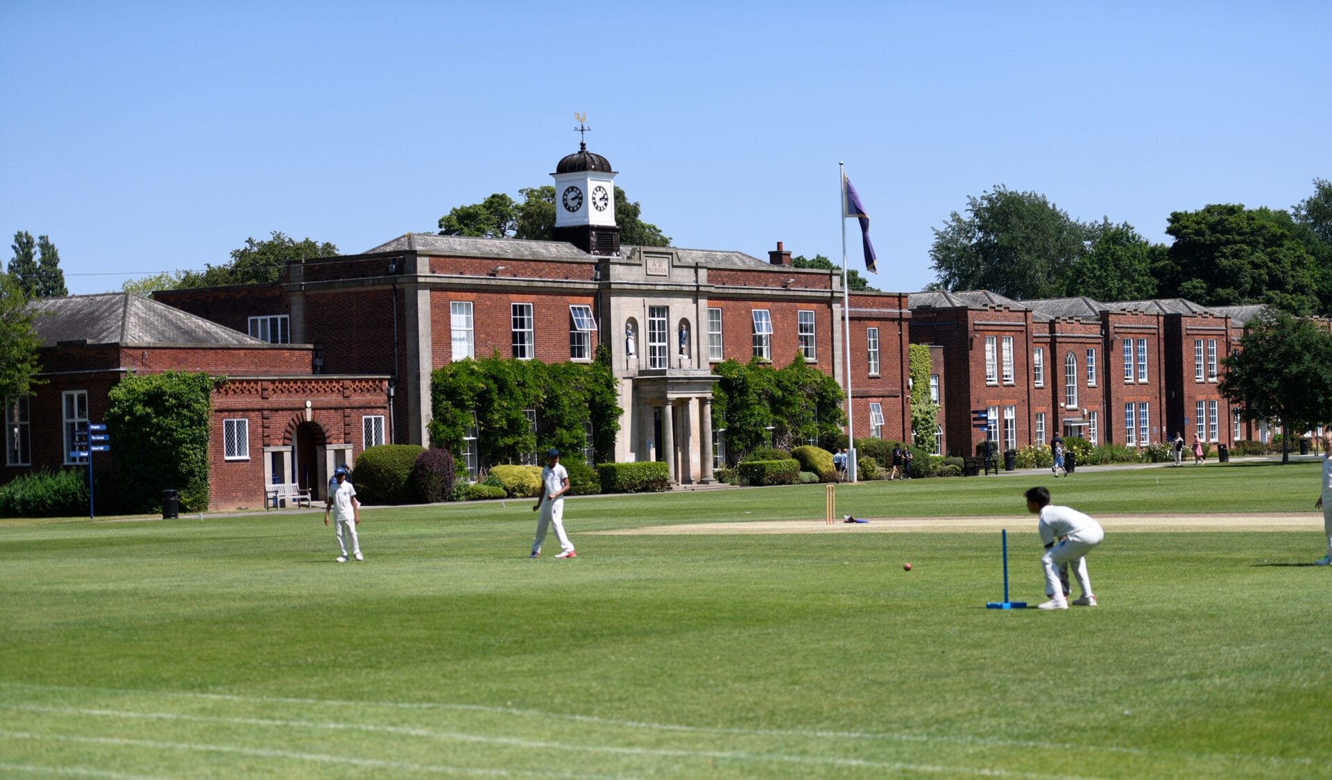 Pupils playing cricket on the field at the front of The Blue Coat School.