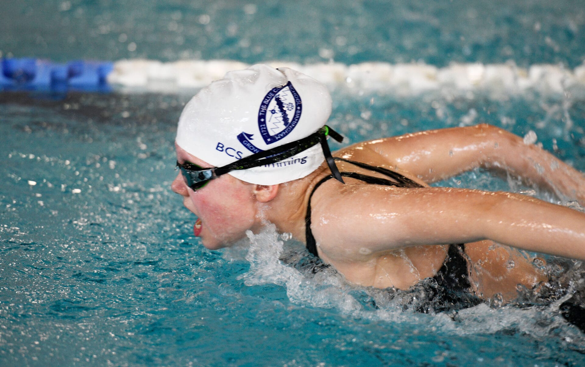Girl swimming wearing a white BCS swimming cap