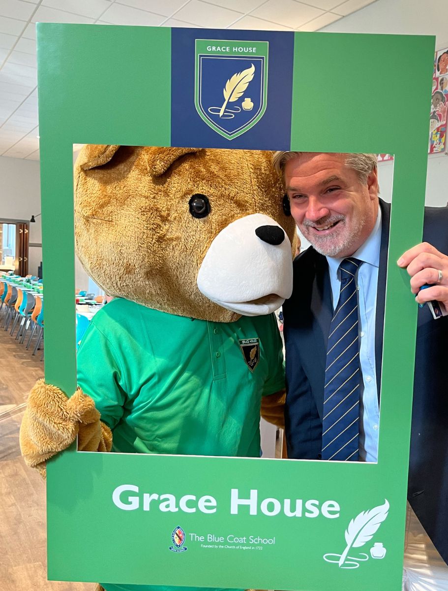 Headmaster, Noel Neeson poses for a photo in the Grace House selfie frame with Bluey the Bear.