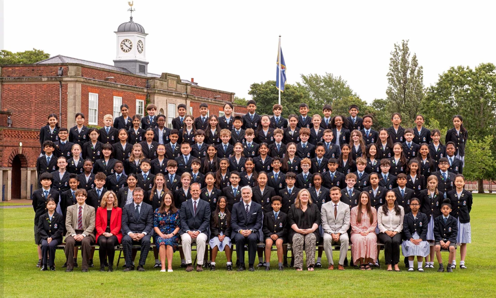 The Class of Year 6 2026 smiling at the camera with their teachers for a formal end of school photo.