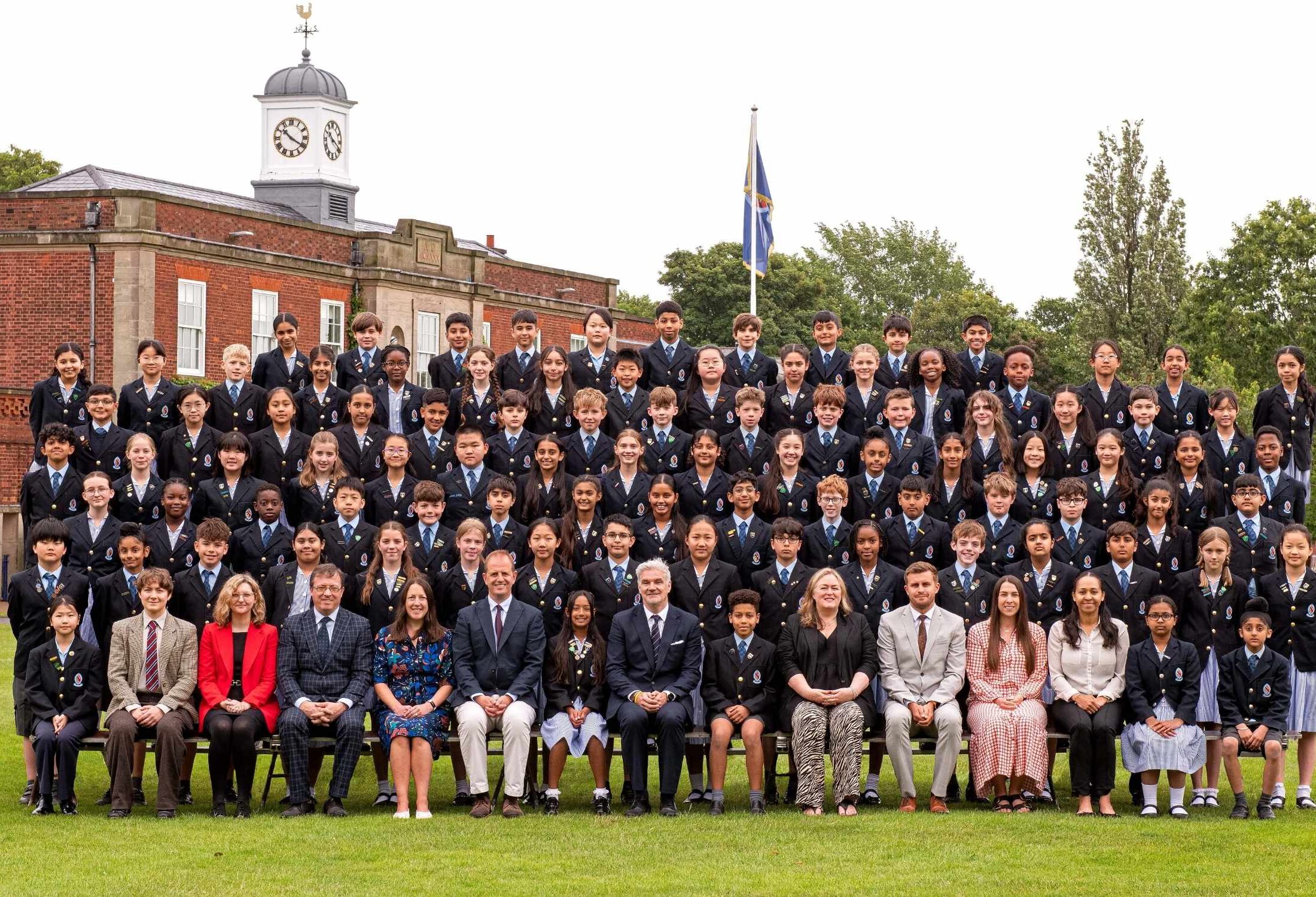 The Class of Year 6 2026 smiling at the camera with their teachers for a formal end of school photo.