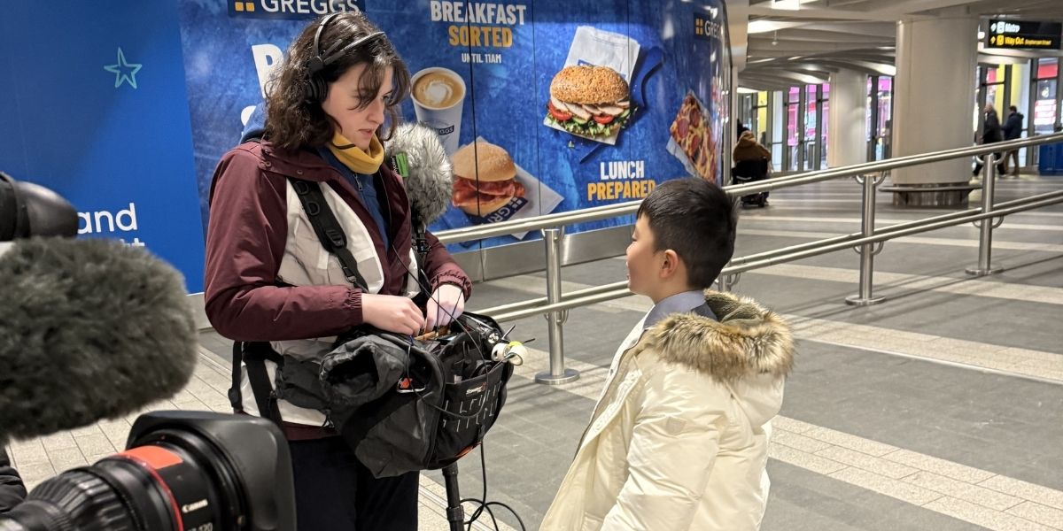 Bowen talks to a camera woman during filming of The Piano at New Street Station