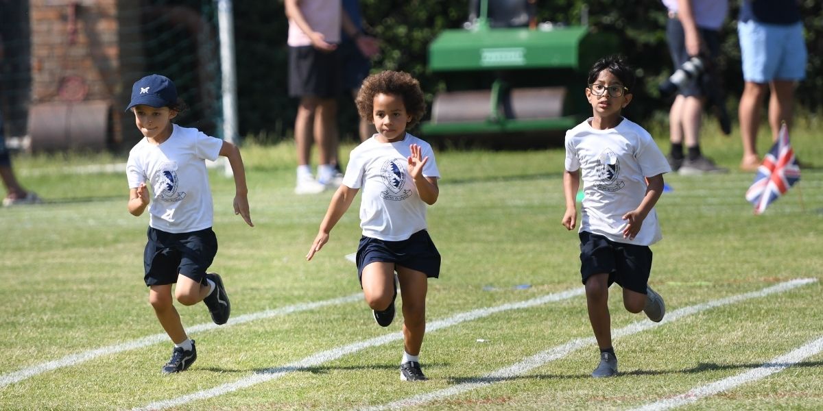 Three pupils run in a race at Pre-Prep sports day.