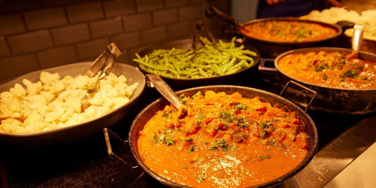 Pots of cauliflower, green beans and curry on the serving bar for lunch at The Blue Coat School Birmingham